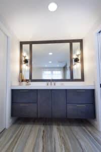 bathroom remodel with a dark oak finish with golden handles and new light fixture