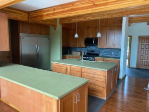 Finished kitchen area with green countertops and wooden beams